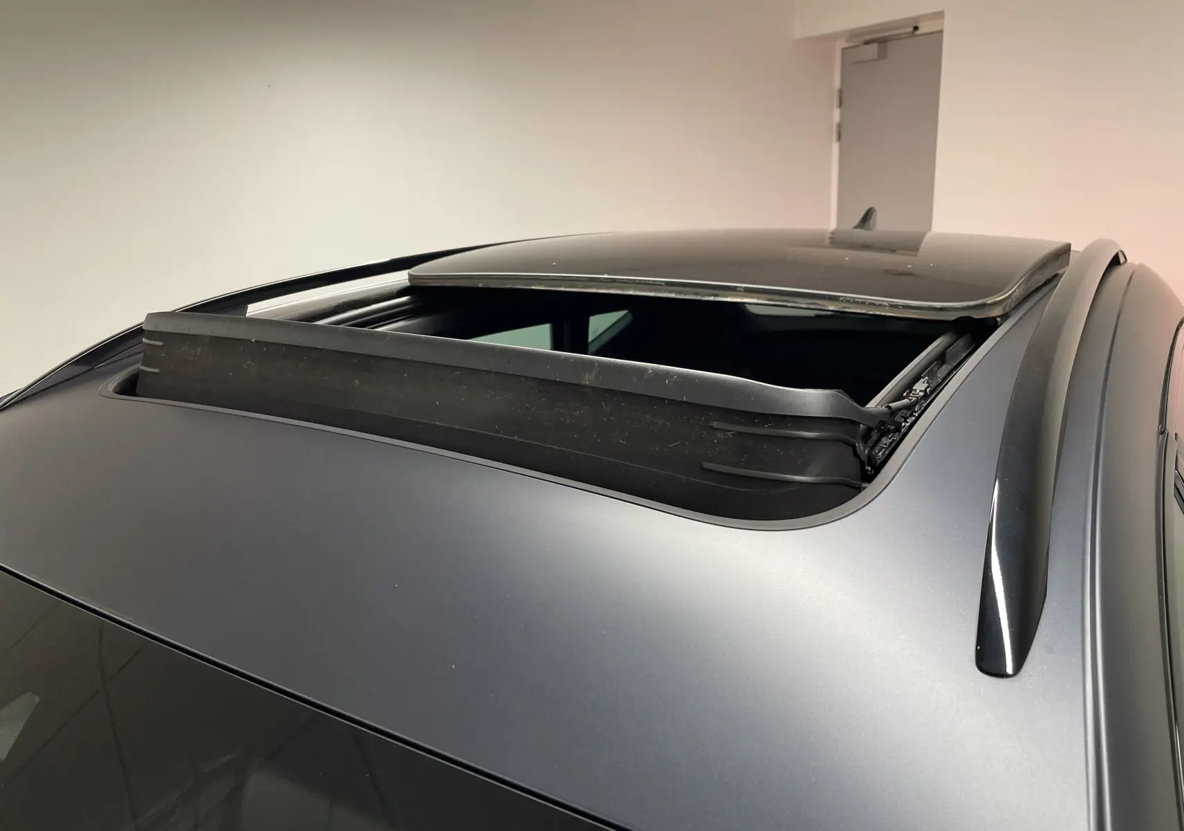 Toit ouvrant panoramique ouvert sur un CUPRA Formentor gris magnétique mat, vue rapprochée sur le toit et les barres de toit.