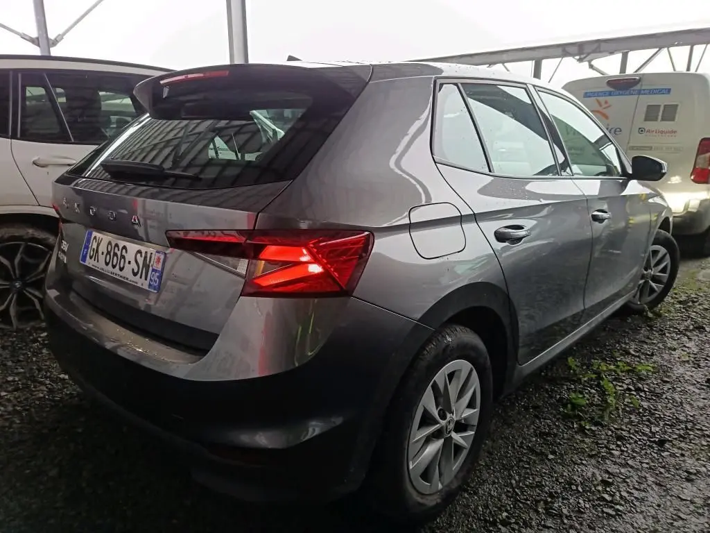 Vue 3/4 arrière droite d'une Skoda Fabia gris graphite 2022 avec feux arrière allumés et jantes 15 pouces.