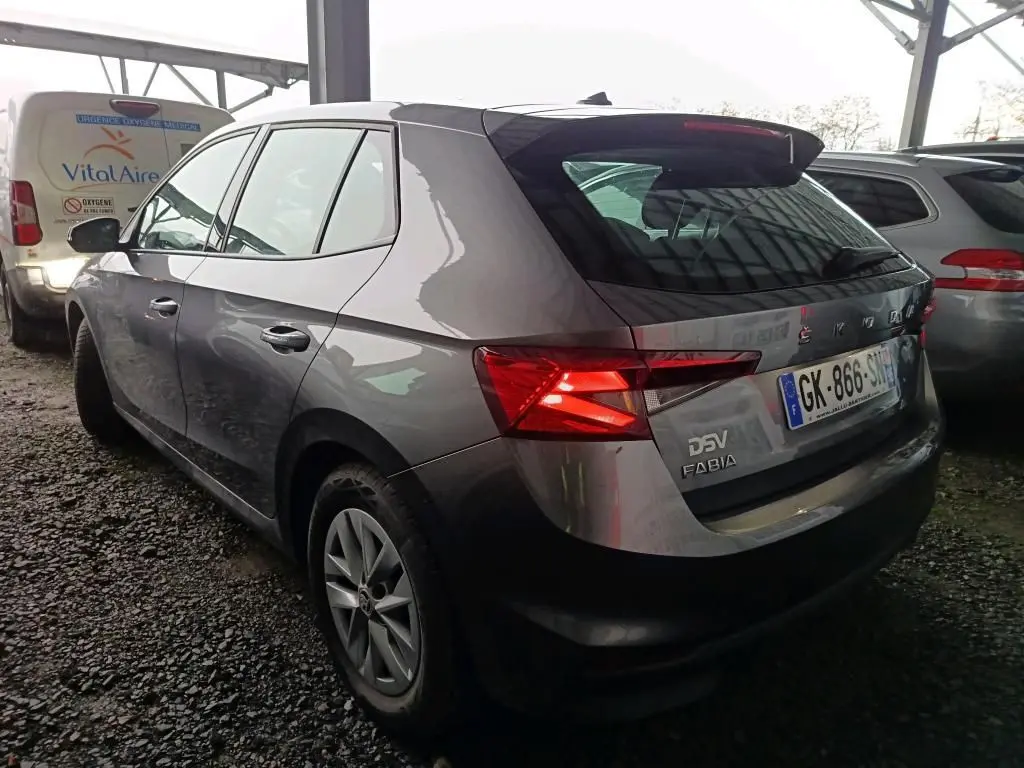 Vue 3/4 arrière gauche d'une Skoda Fabia gris graphite 2022 avec feux arrière allumés et jantes 15 pouces.