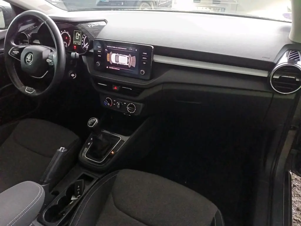 Vue intérieure côté conducteur de la Skoda Fabia 1.0 TSI 95 Ambition 2022 avec tableau de bord noir et écran tactile central.