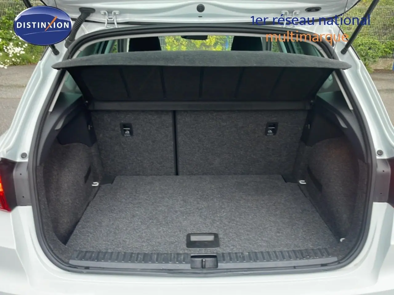 Coffre ouvert vu de l'arrière d'un SEAT Arona blanc alpin métal avec toit noir, montrant l'espace de chargement vide.