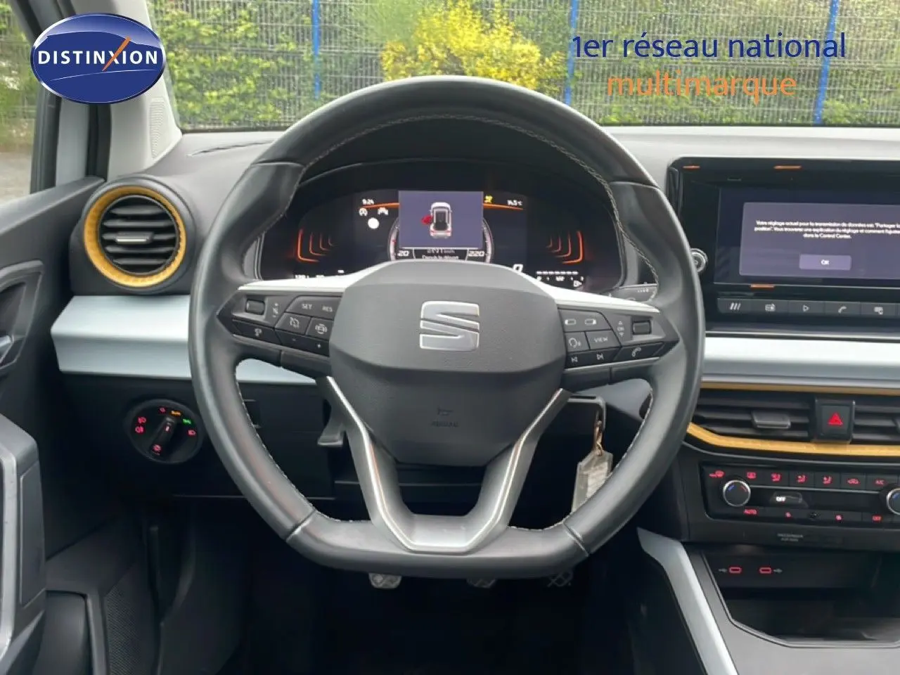 Vue centrée sur le volant et le tableau de bord du SEAT Arona 2025, intérieur noir avec touches jaunes.