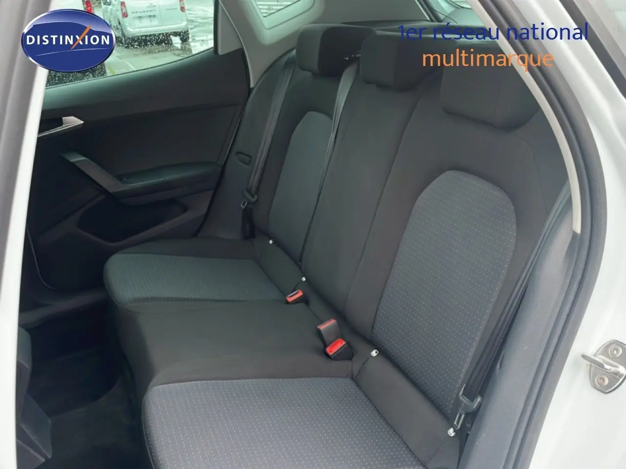 Vue intérieure côté droit montrant la banquette arrière en tissu noir avec détails gris d'un SEAT Arona blanc 2025.