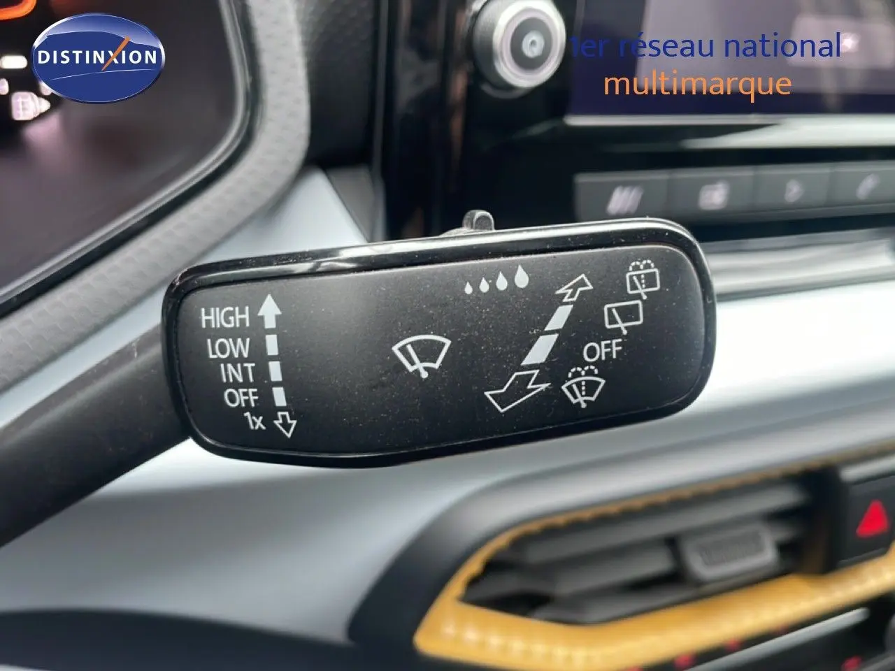 Gros plan sur la commande des essuie-glaces dans l’habitacle d’une SEAT Arona blanche avec toit noir, version 2025.