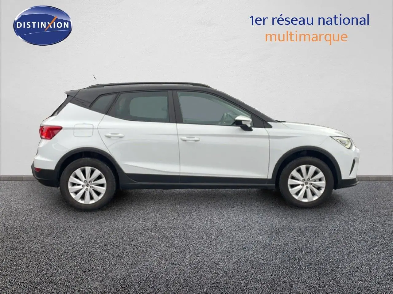 Vue latérale droite du SEAT Arona blanc alpin avec toit noir, soulignant son profil compact et moderne.