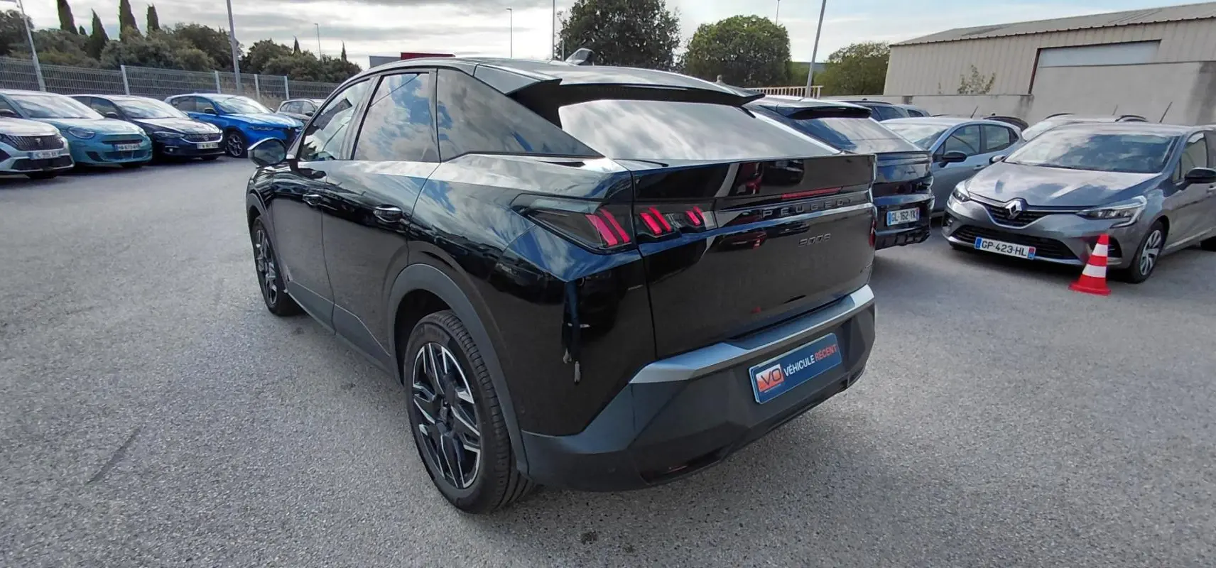 Vue 3/4 arrière gauche d’un Peugeot 3008 Hybrid noir avec jantes alliage 19 pouces et feux arrière distinctifs.