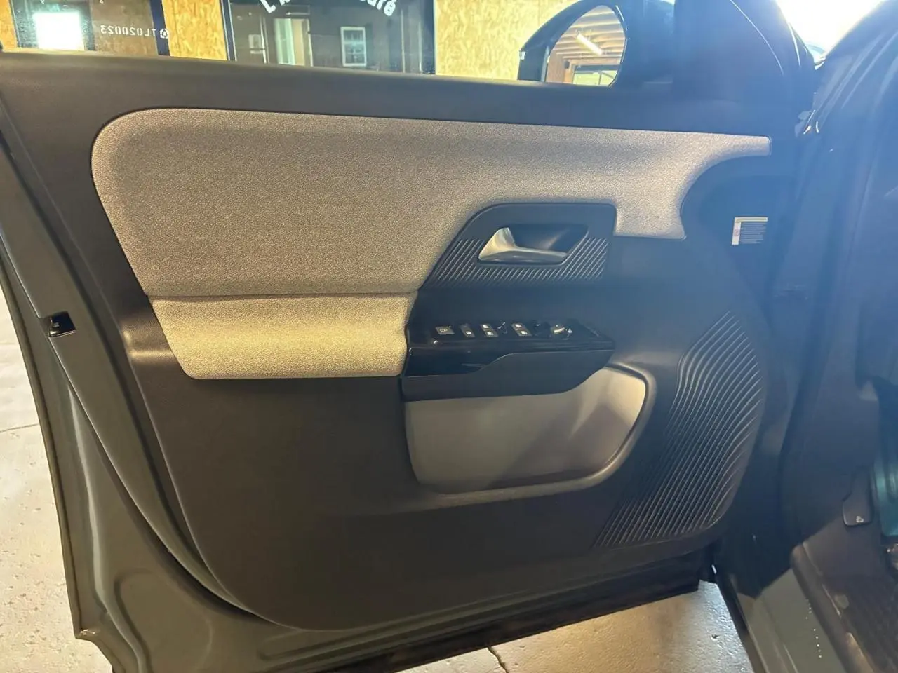 Détail de la porte intérieure côté conducteur du Citroën C5 Aircross 2026, montrant les commandes et matériaux noirs et gris.