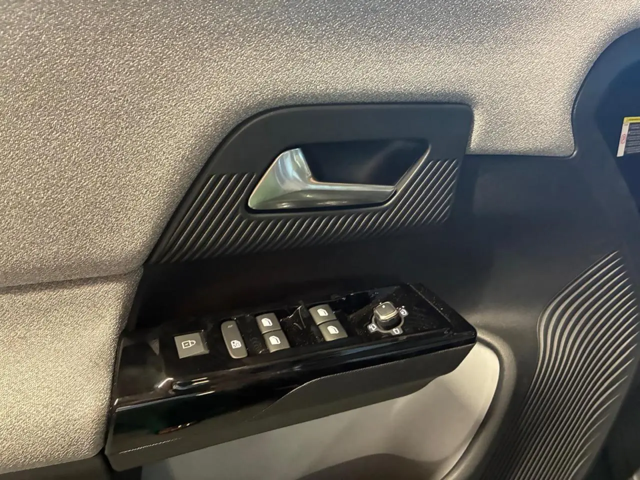 Détail de la porte côté conducteur du Citroën C5 Aircross 2026 vert, avec commandes de vitres et poignée argentée.