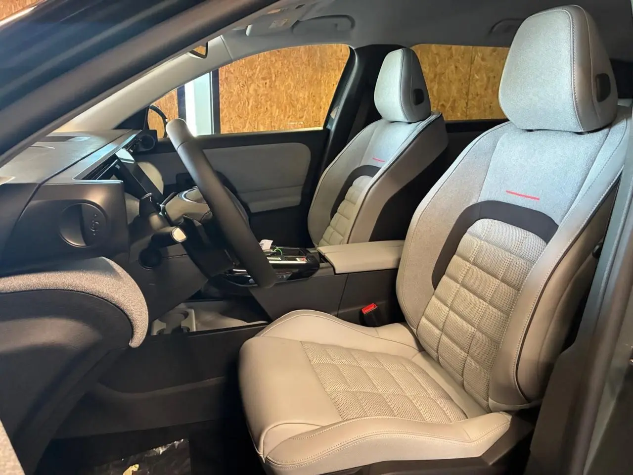 Vue intérieure côté gauche du Citroën C5 Aircross 2026, sièges gris clair avec surpiqûres rouges et tableau de bord moderne.