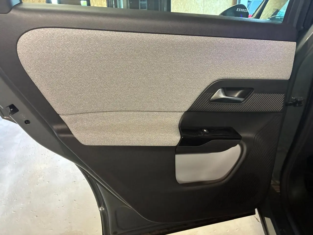 Porte arrière côté droit du Citroën C5 Aircross 2026 vert, avec habillage bicolore gris clair et noir.