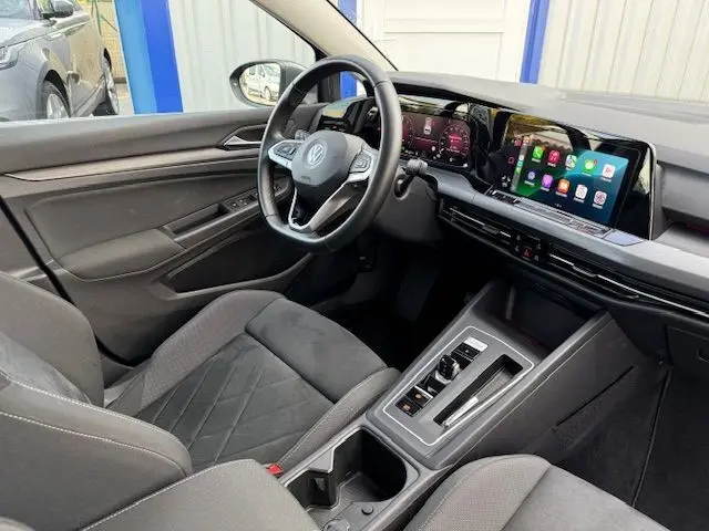 Intérieur de Volkswagen Golf VIII 1.4 e-Hybrid 2021, vue côté conducteur, tableau de bord numérique et écran tactile coloré.
