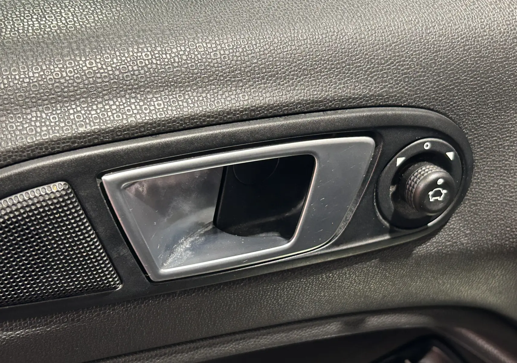 Poignée intérieure de porte côté gauche du Ford EcoSport gris 2018 avec réglage manuel des rétroviseurs.