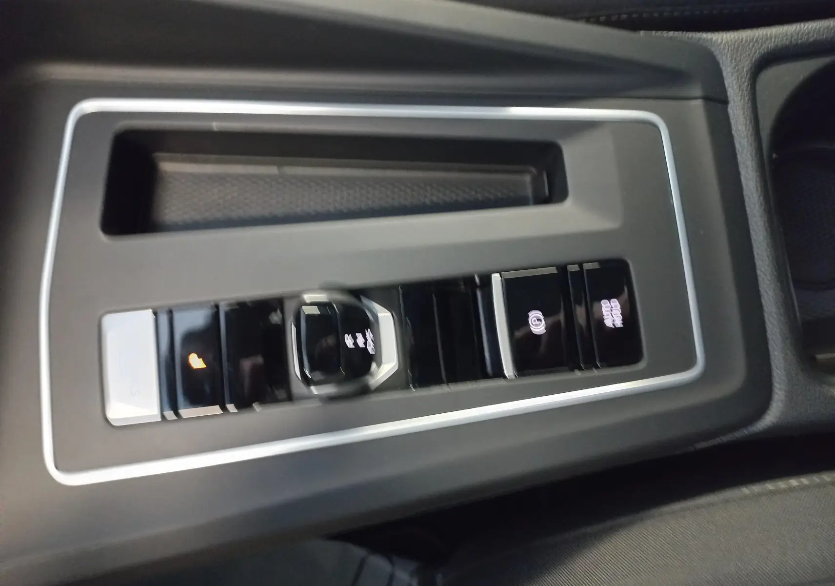 Gros plan sur la console centrale de la Volkswagen Golf 1.5 eHybrid 2025, avec commandes de boîte auto et frein à main électronique.