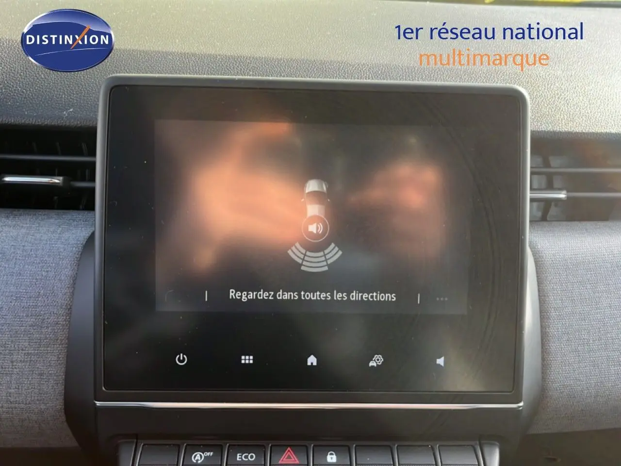 Écran tactile central de la Renault Clio gris schiste, affichant une alerte de surveillance des angles morts.