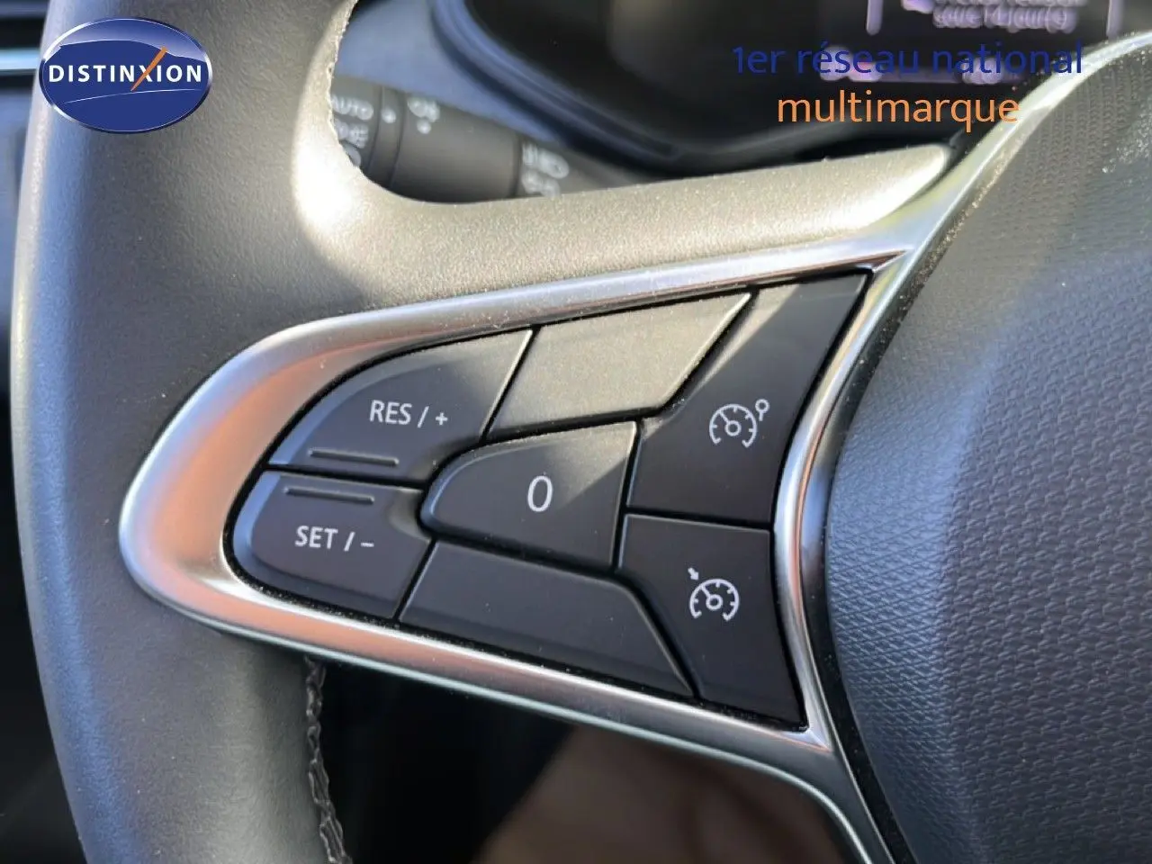 Gros plan sur les commandes de régulateur de vitesse au volant d’une Renault Clio gris schiste métal, version 2025.