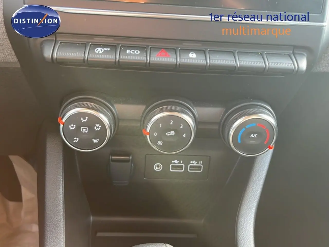 Vue rapprochée des commandes de climatisation et des ports USB du tableau de bord de la Renault Clio gris schiste 2025.