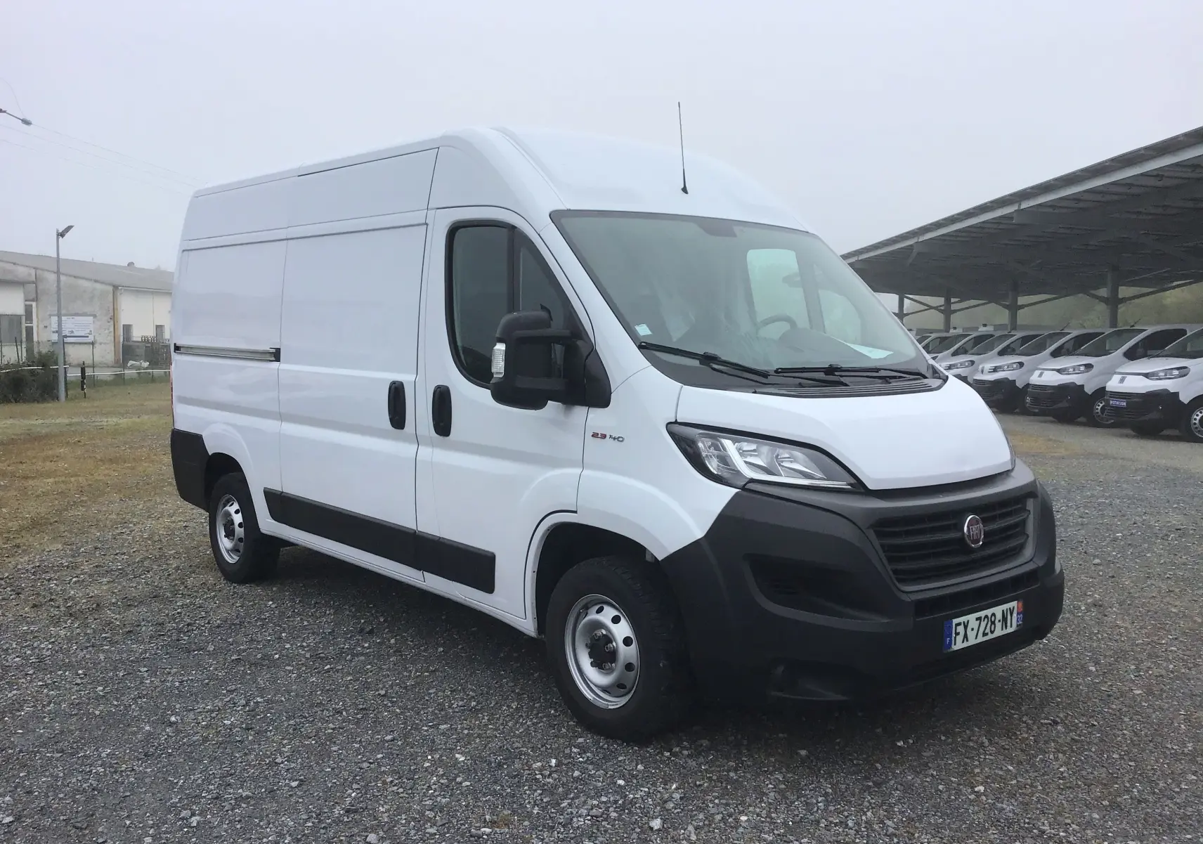 FIAT Ducato Fourgon blanc vu en 3/4 avant droit, avec pare-chocs noirs et grandes portes latérales coulissantes.