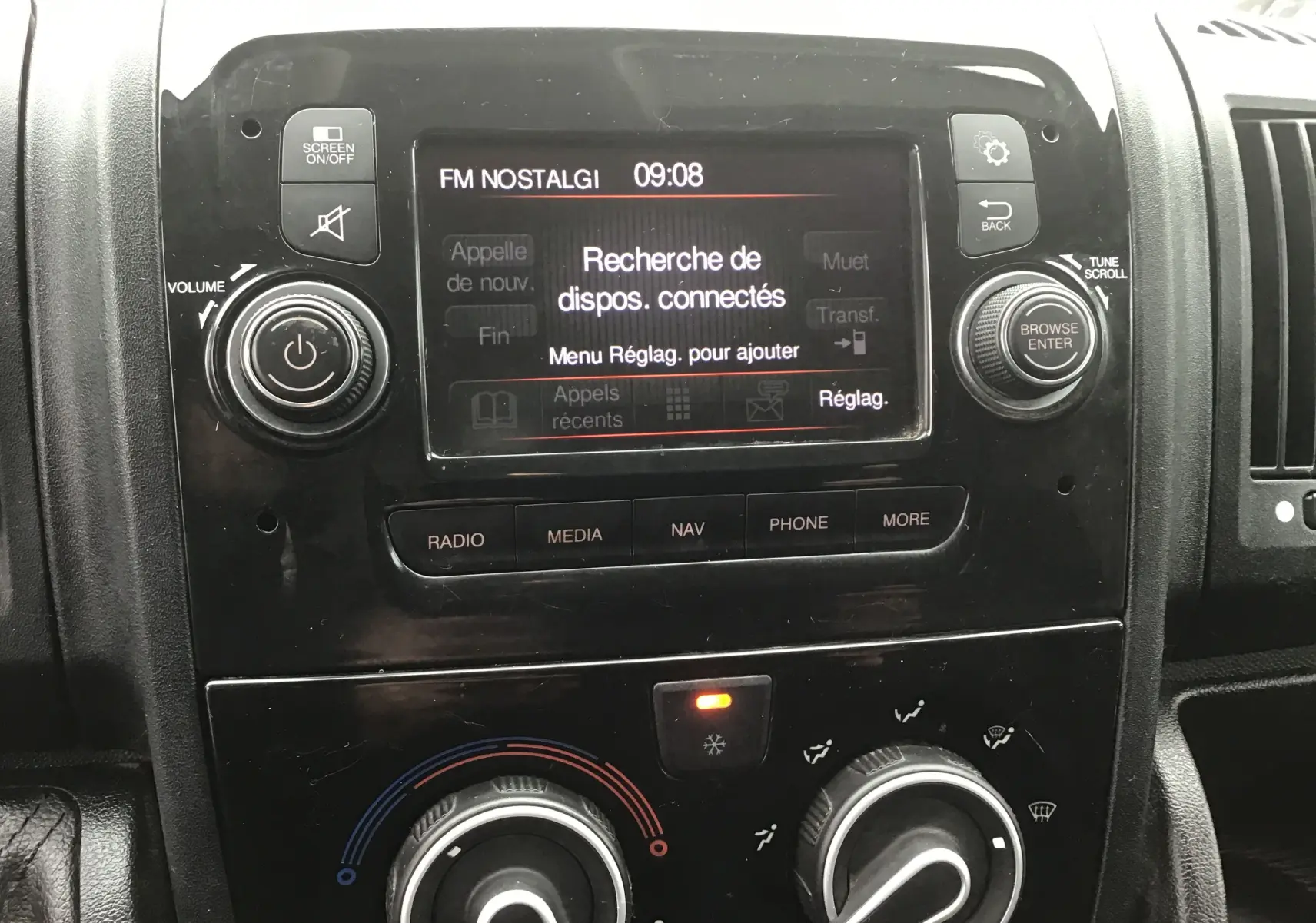 Vue rapprochée du tableau de bord noir du Fiat Ducato Fourgon blanc, avec écran central affichant la recherche de dispositifs connectés.