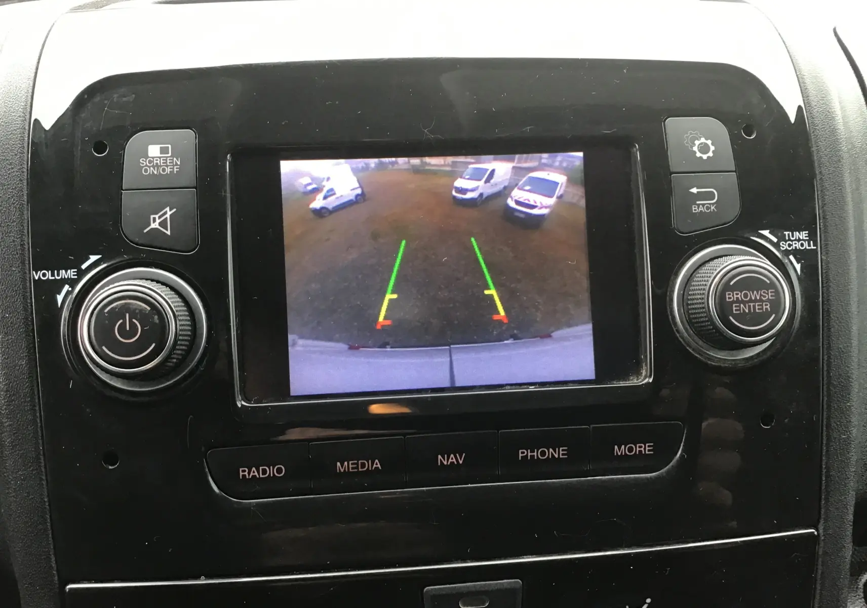 Vue rapprochée de l’écran central du Fiat Ducato blanc 2021 montrant la caméra de recul avec lignes de guidage colorées.