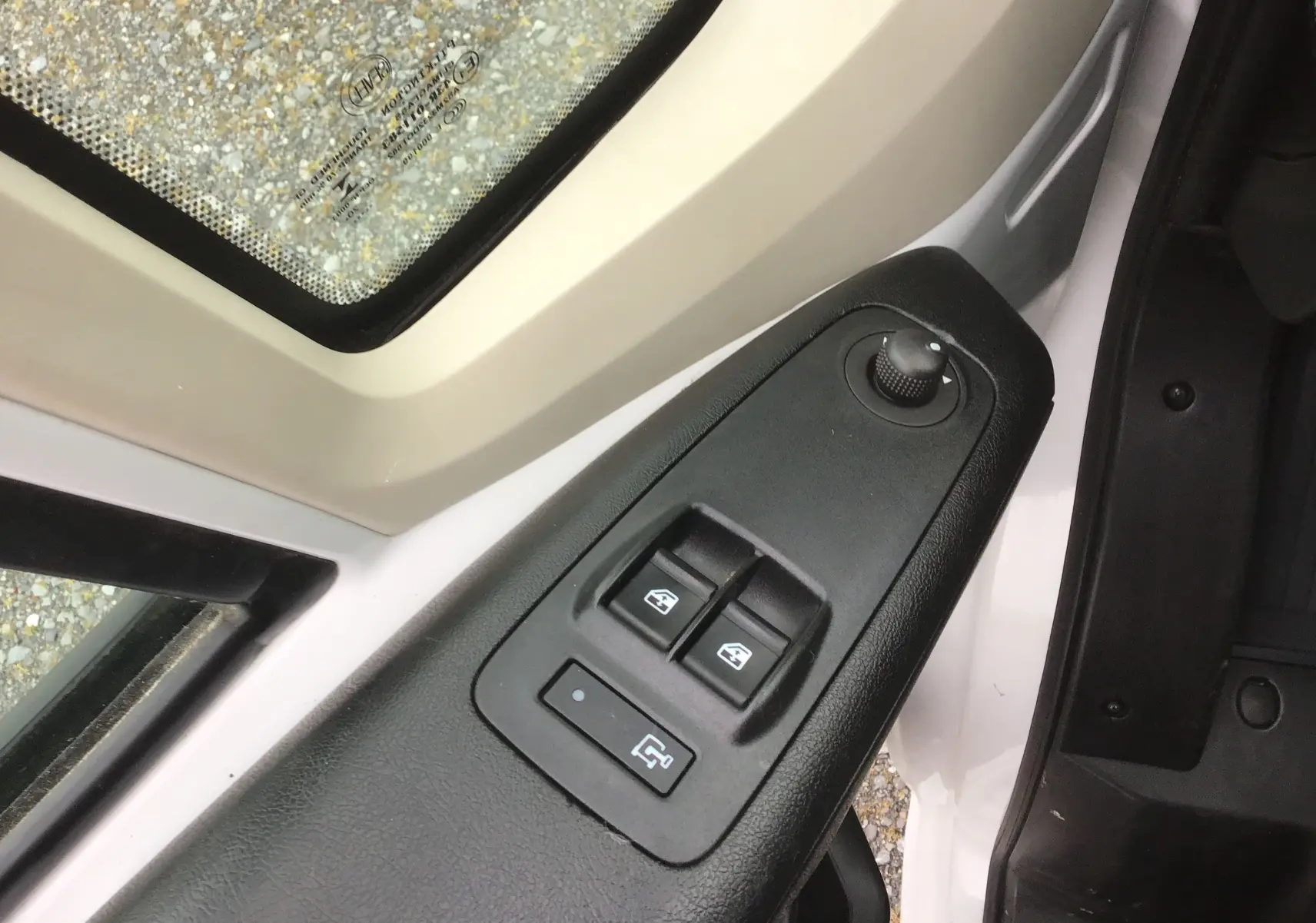 Gros plan sur la commande des vitres électriques côté conducteur du Fiat Ducato blanc, avec réglage des rétroviseurs.