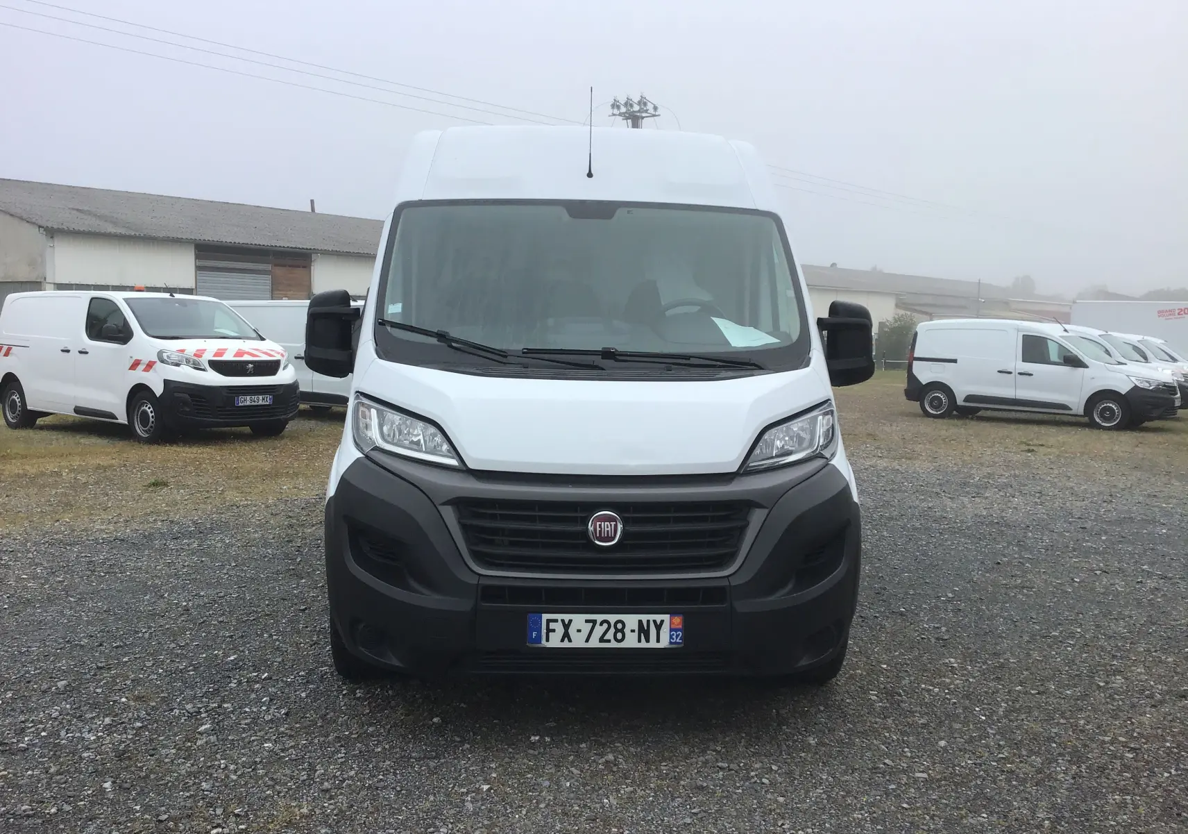 Vue frontale d’un fourgon FIAT Ducato blanc avec calandre noire et plaque d’immatriculation française visible.