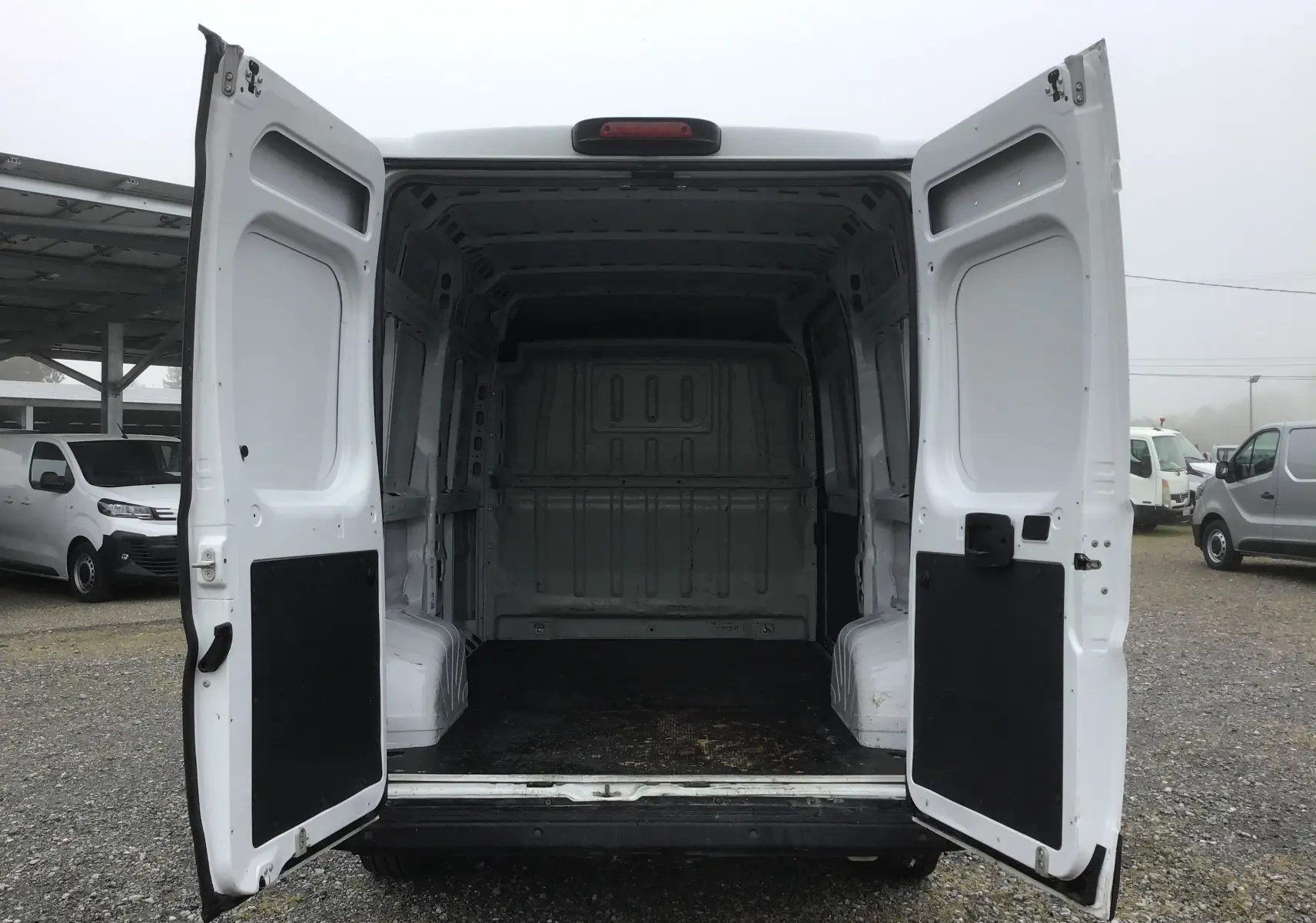 Vue arrière du FIAT Ducato Fourgon blanc 2021 avec portes arrière ouvertes, montrant l'espace de chargement vide.