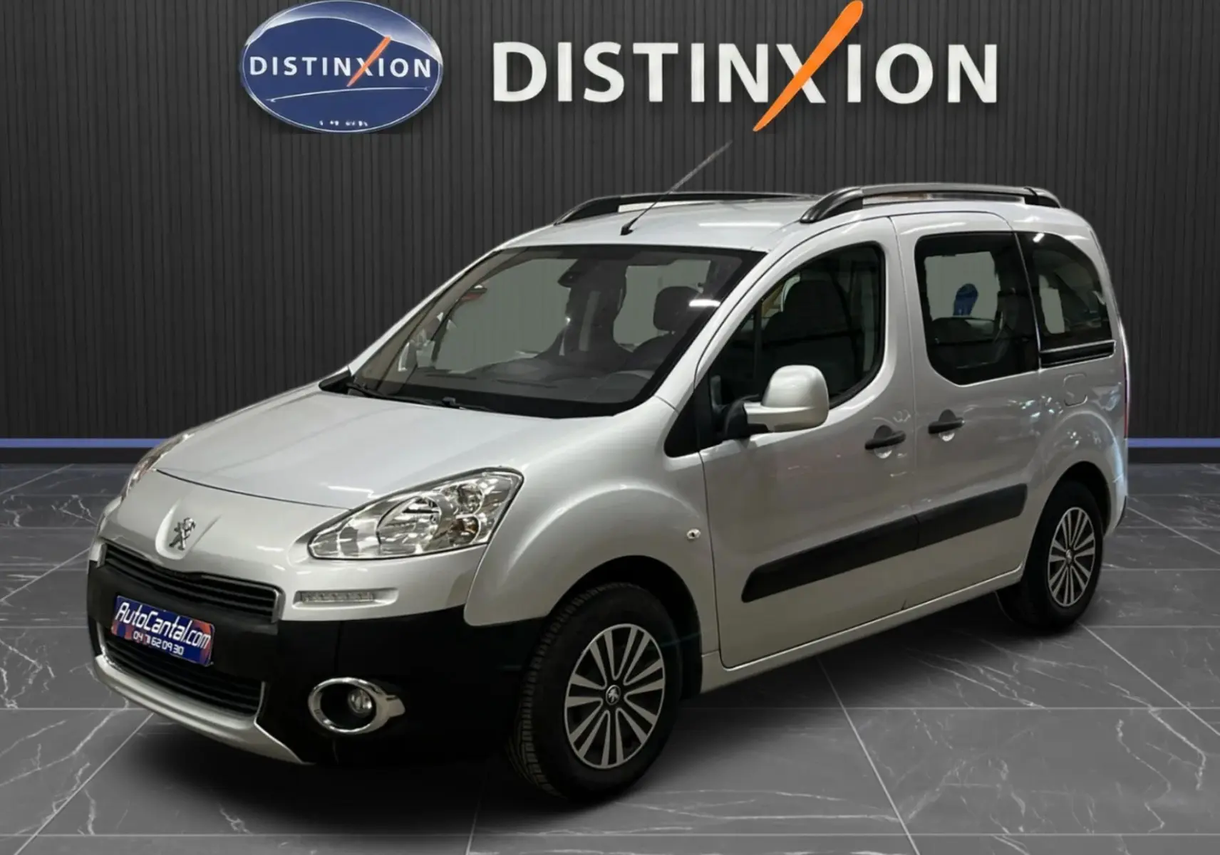 Peugeot Partner Tepee gris aluminium vu en 3/4 avant droit, avec barres de toit et jantes spécifiques.