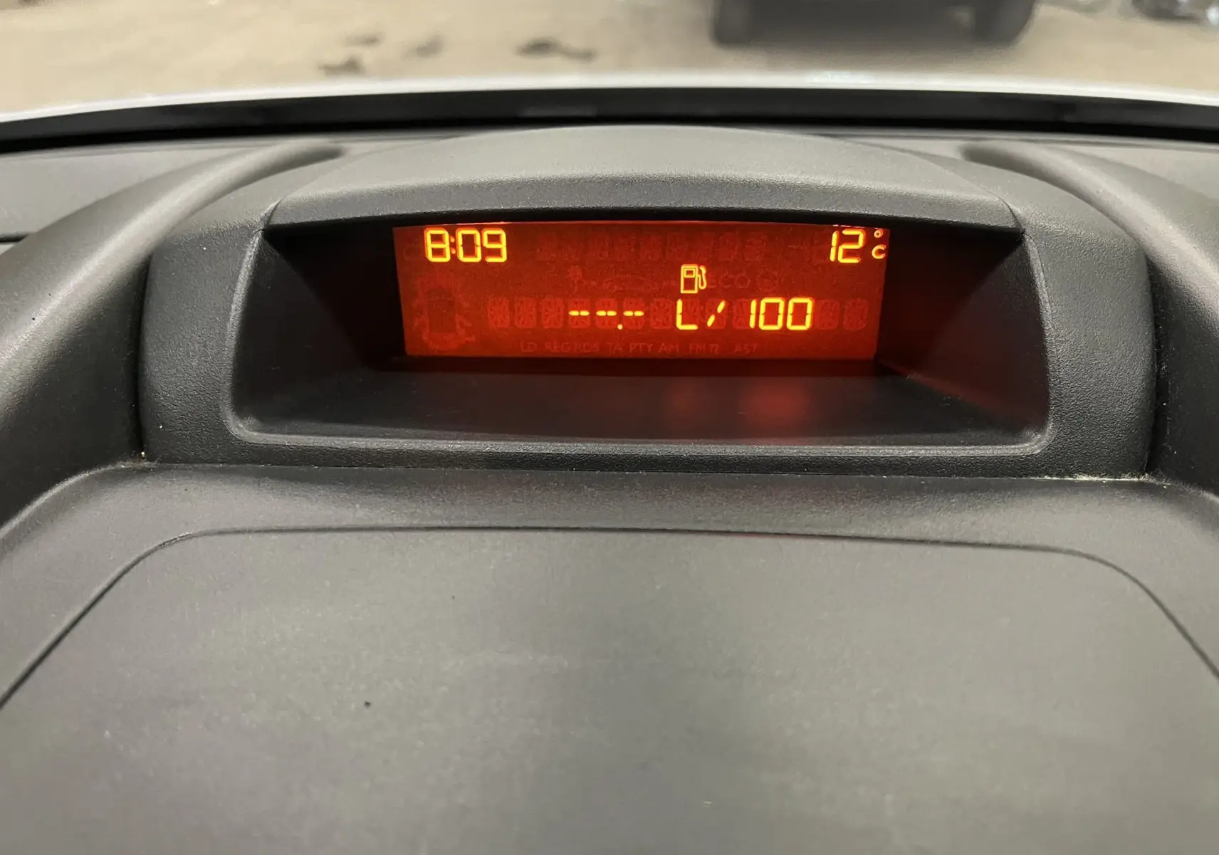 Affichage numérique orange du tableau de bord du Peugeot Partner Tepee 2013, indiquant l'heure et la température extérieure.