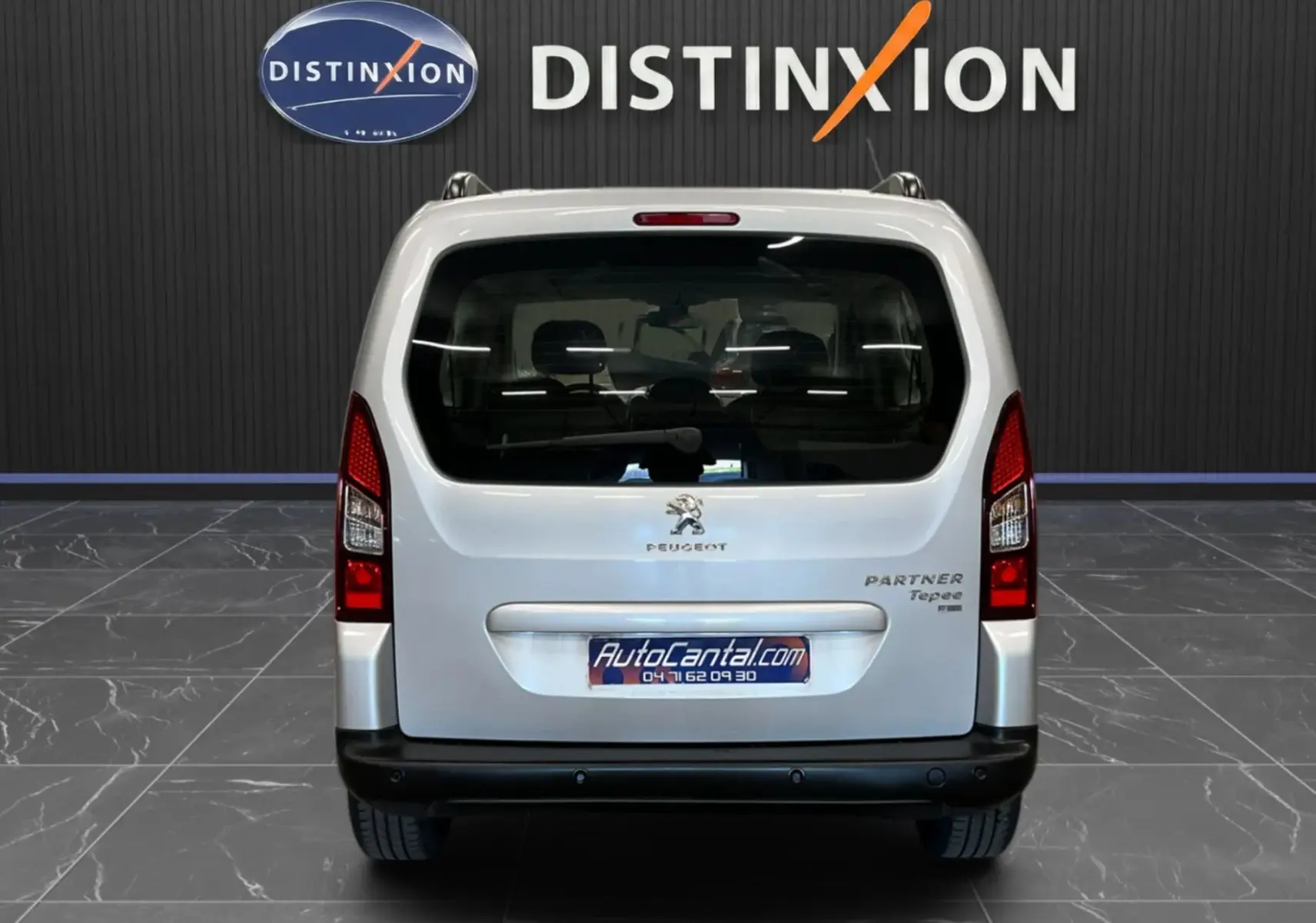 Vue arrière d'un Peugeot Partner Tepee gris aluminium 2013 avec hayon et vitres arrière teintées.