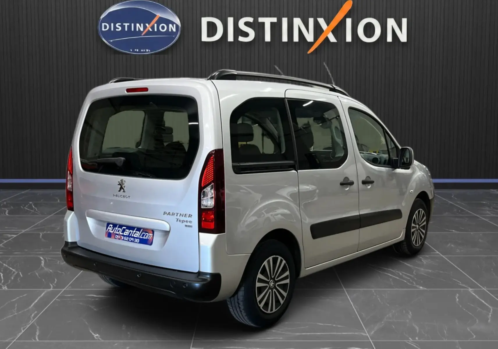 Vue 3/4 arrière droite du Peugeot Partner Tepee gris aluminium, avec portes latérales coulissantes et barres de toit visibles.