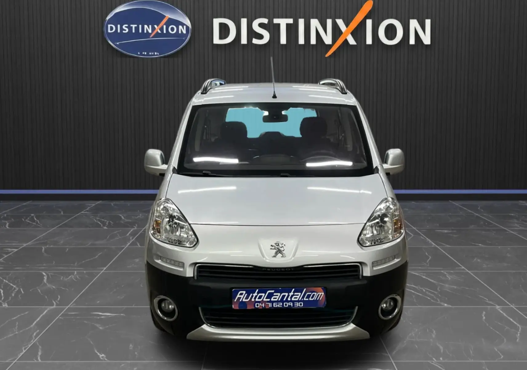 Vue avant d’un Peugeot Partner Tepee gris aluminium avec pare-chocs noir et toit équipé de barres de toit.