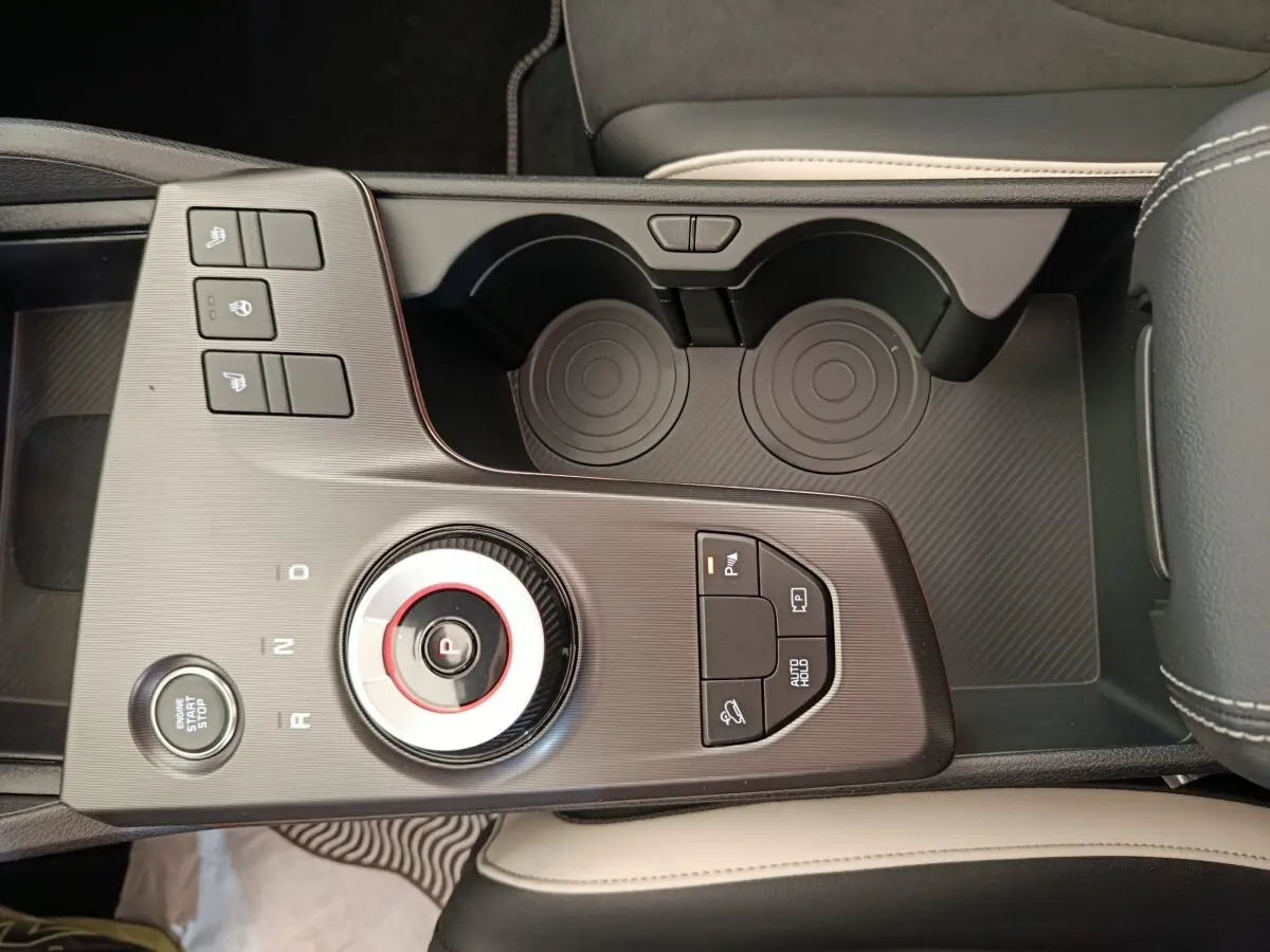 Vue rapprochée de la console centrale noire et grise du Kia Sportage 2026 avec molette de sélection et boutons multifonctions.