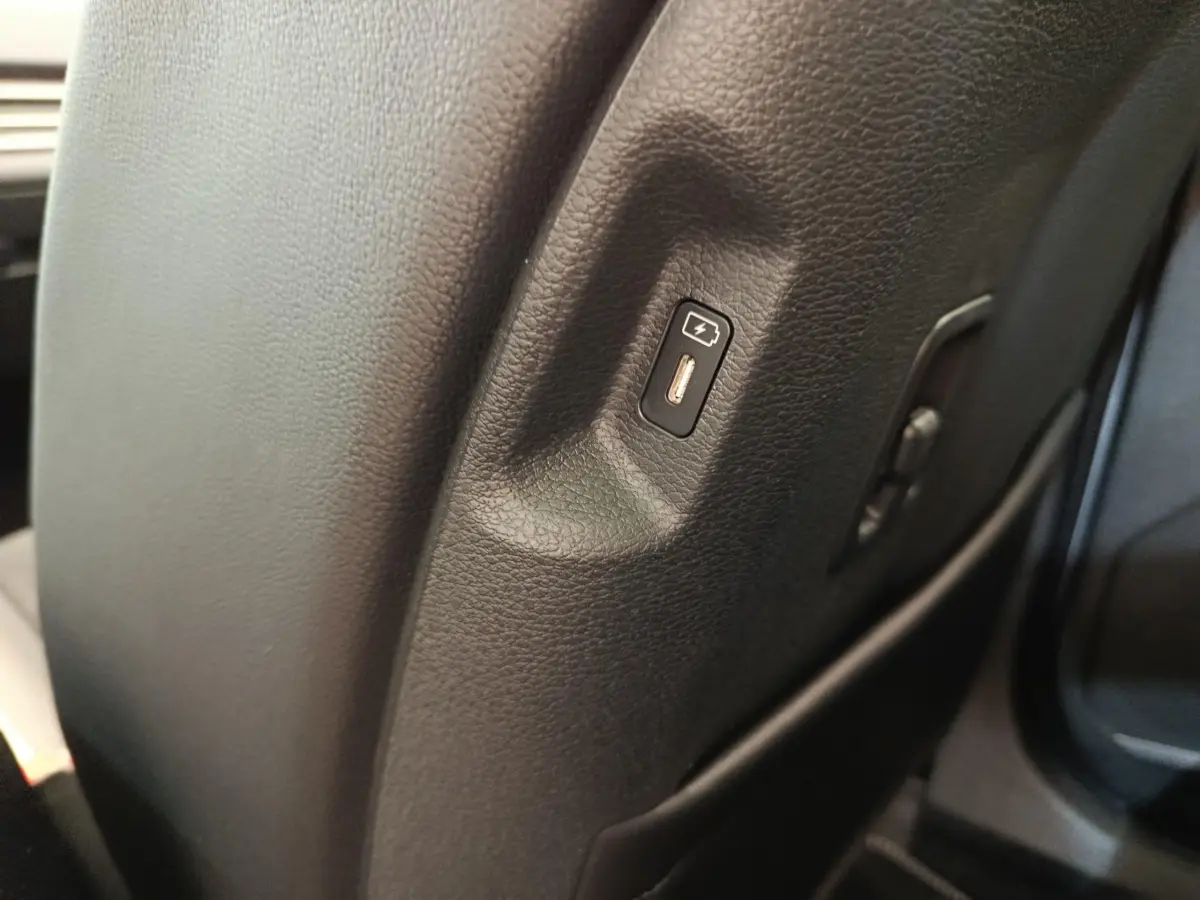 Prise USB intégrée sur le côté droit du siège avant en cuir noir du Kia Sportage gris clair 2026.