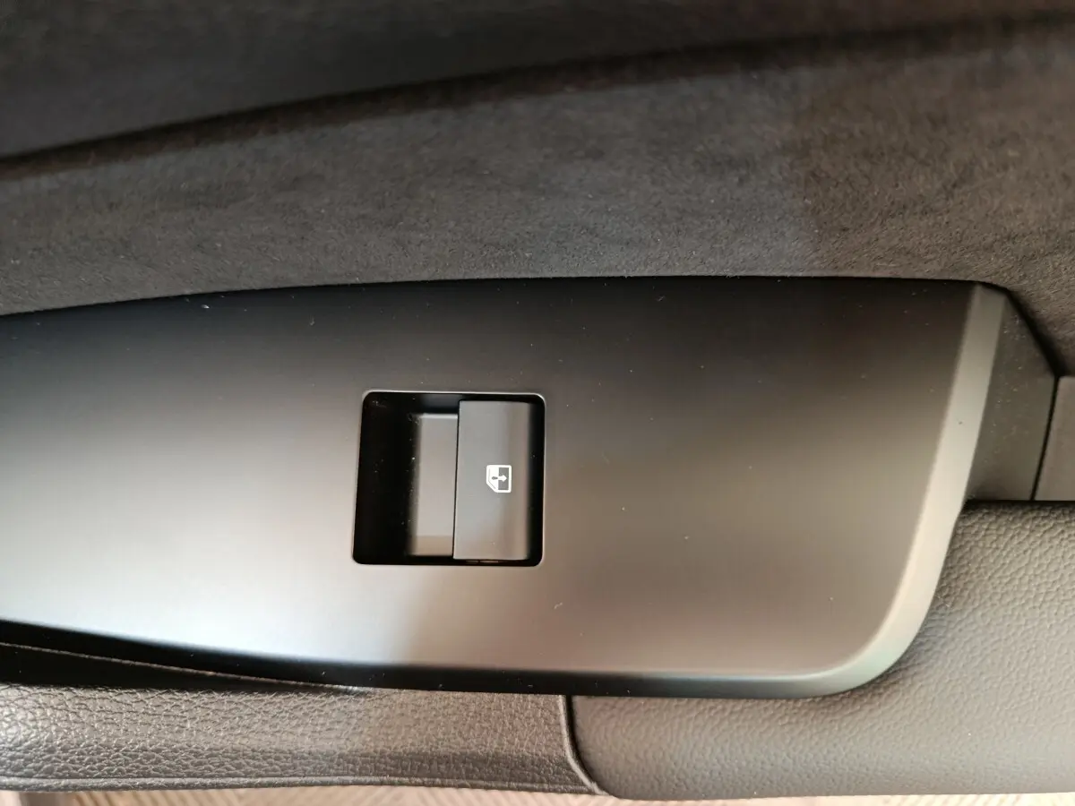 Bouton de commande de lève-vitre sur panneau de porte intérieur noir du KIA SPORTAGE gris clair.