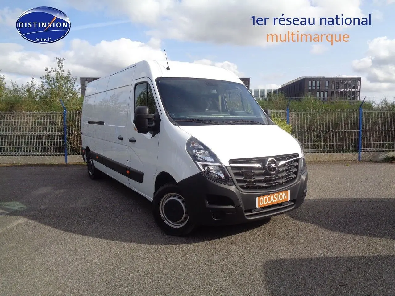 Opel Movano Fourgon blanc polaire vu en 3/4 avant droit sur parking extérieur avec plaque occasion visible