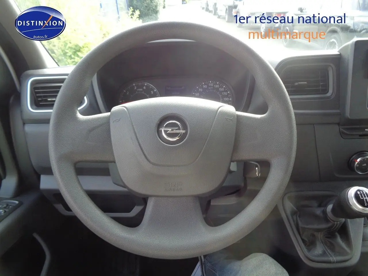 Vue intérieure centrée sur le volant gris d'un Opel Movano Fourgon 2022 avec levier de vitesse manuel visible.
