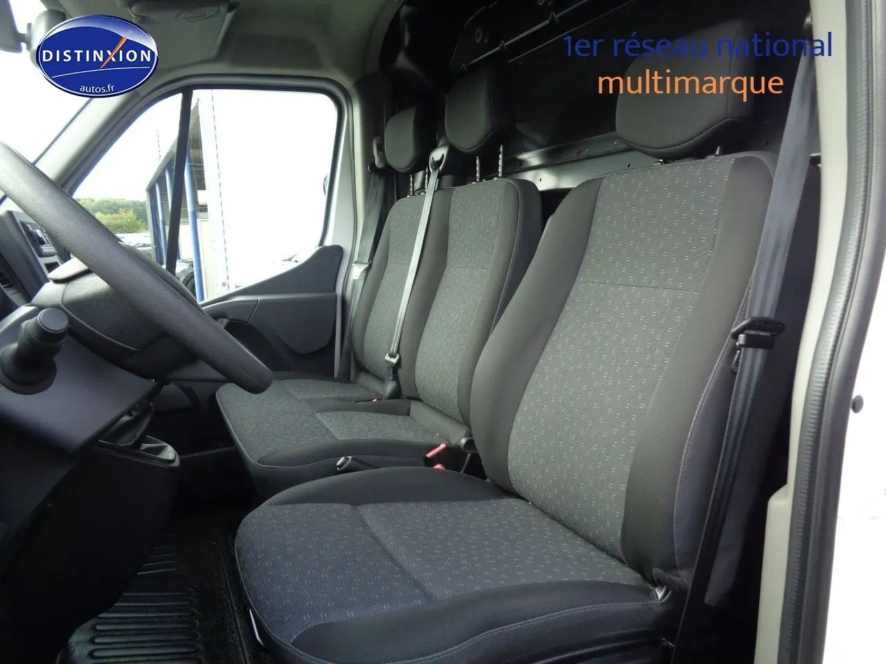 Intérieur du fourgon Opel Movano L3H2 2022, vue côté conducteur sur les sièges tissu gris noir et tableau de bord.