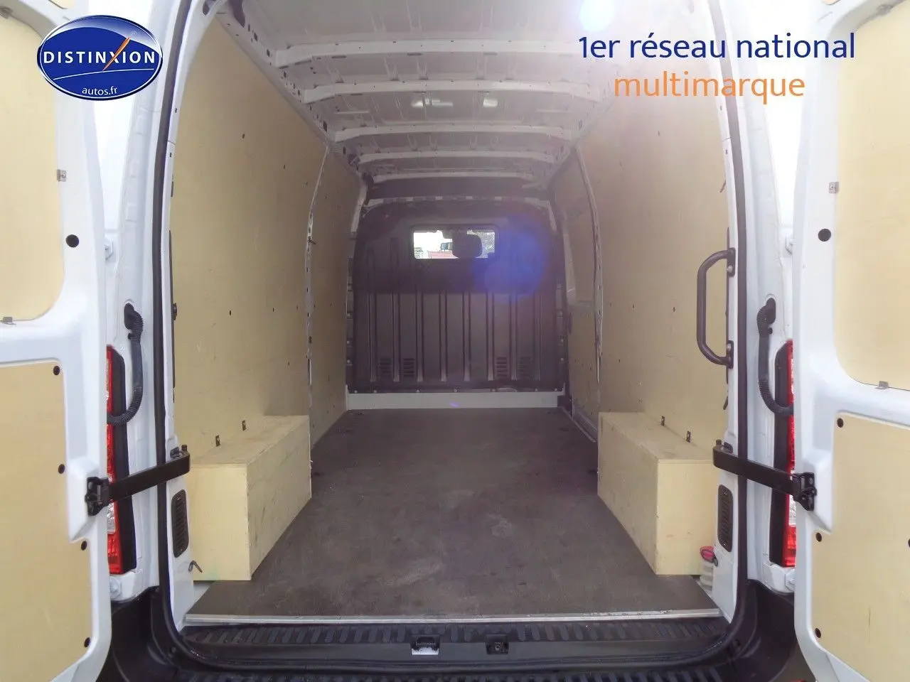 Vue intérieure arrière du fourgon Opel Movano L3H2 blanc polaire, montrant l'espace de chargement vide avec parois protégées.