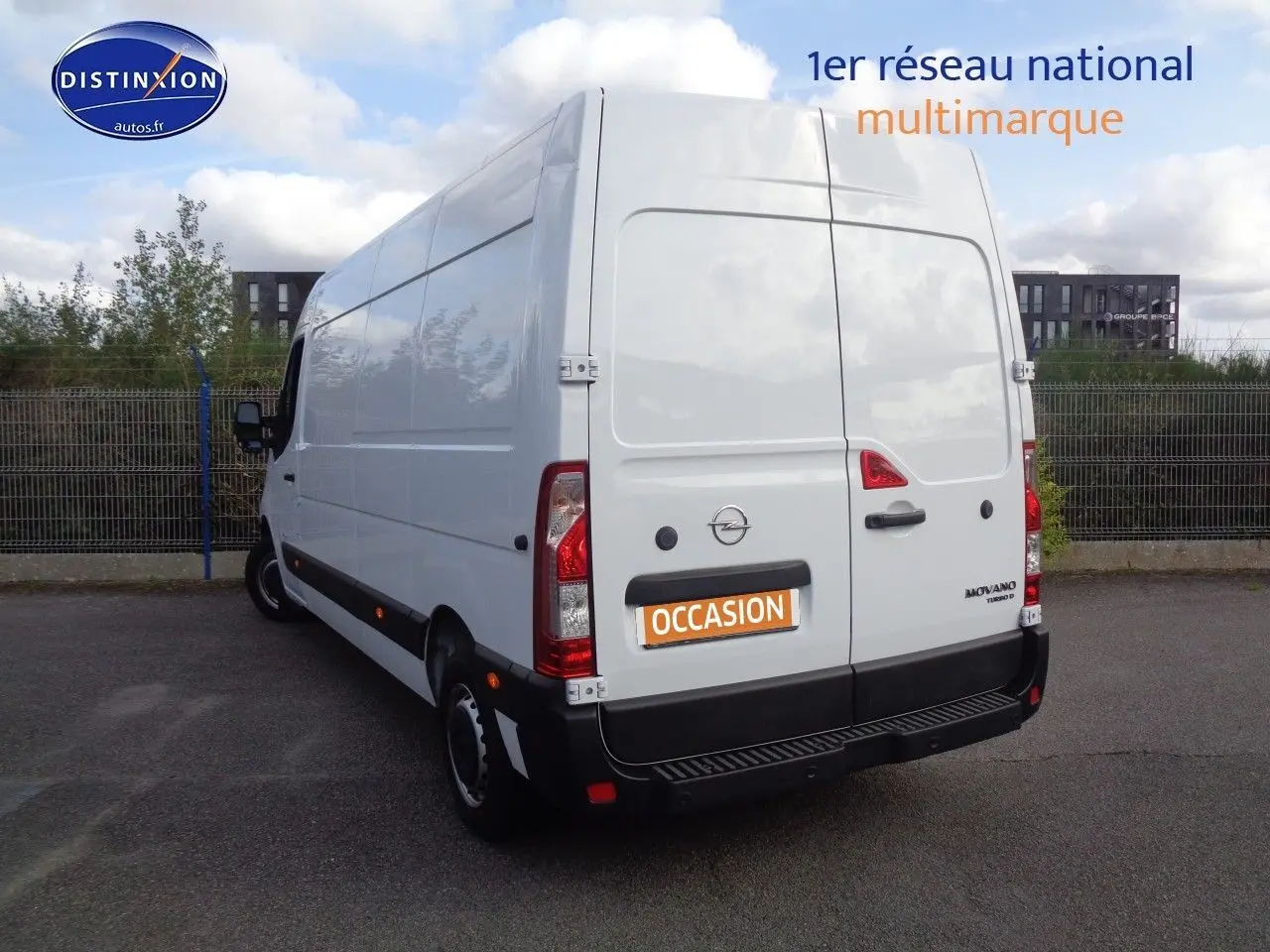 Vue 3/4 arrière gauche d'un Opel Movano Fourgon blanc polaire avec portes arrière fermées sur un parking extérieur.