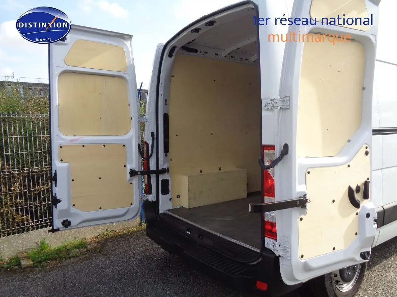 Vue arrière ouverte du fourgon Opel Movano L3H2 blanc polaire, montrant l'espace de chargement vide et les portes arrière garnies de panneaux bois.