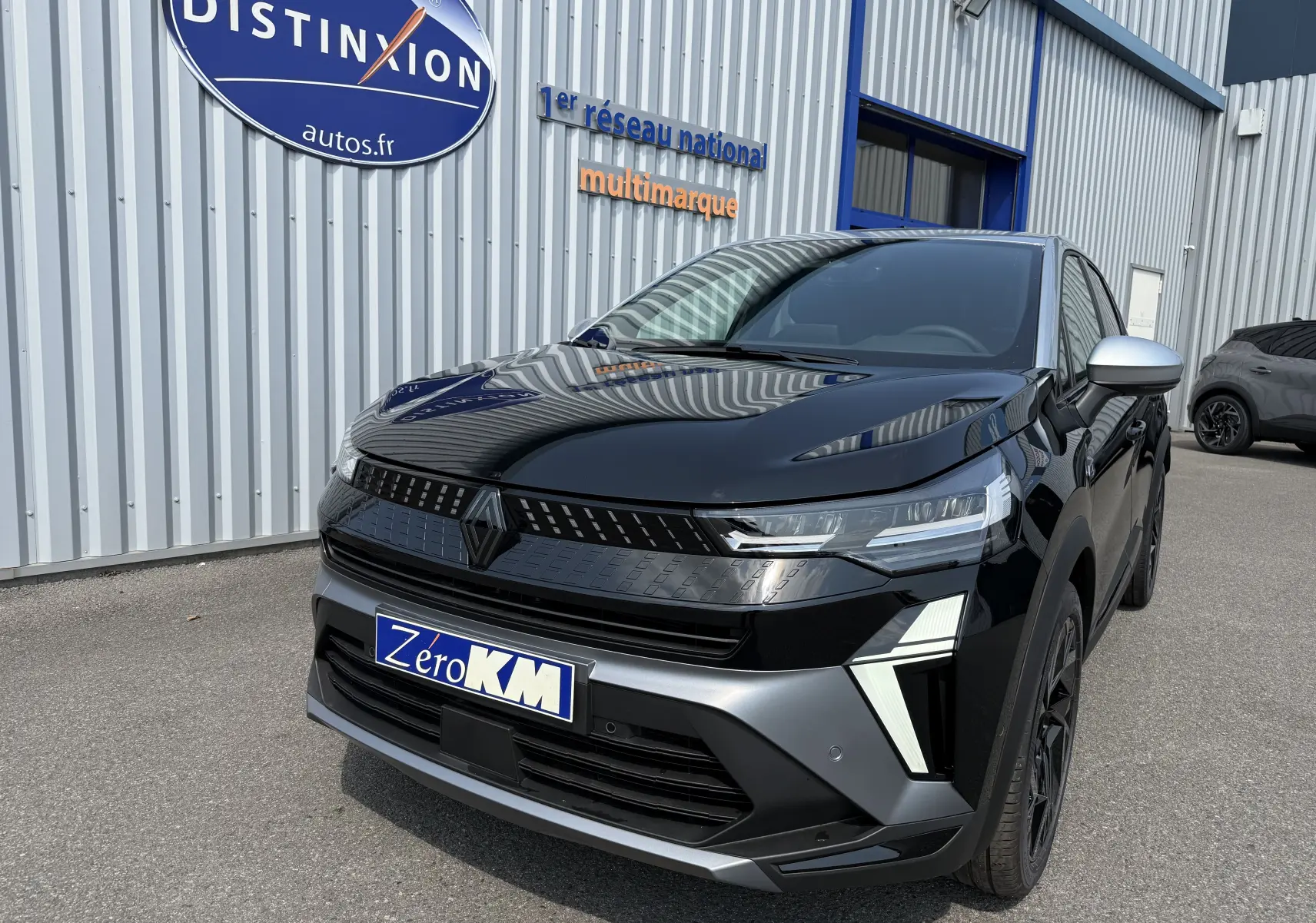Vue 3/4 avant droite d'un Renault Captur noir étoile avec toit gris, mettant en valeur ses phares LED et sa calandre moderne.