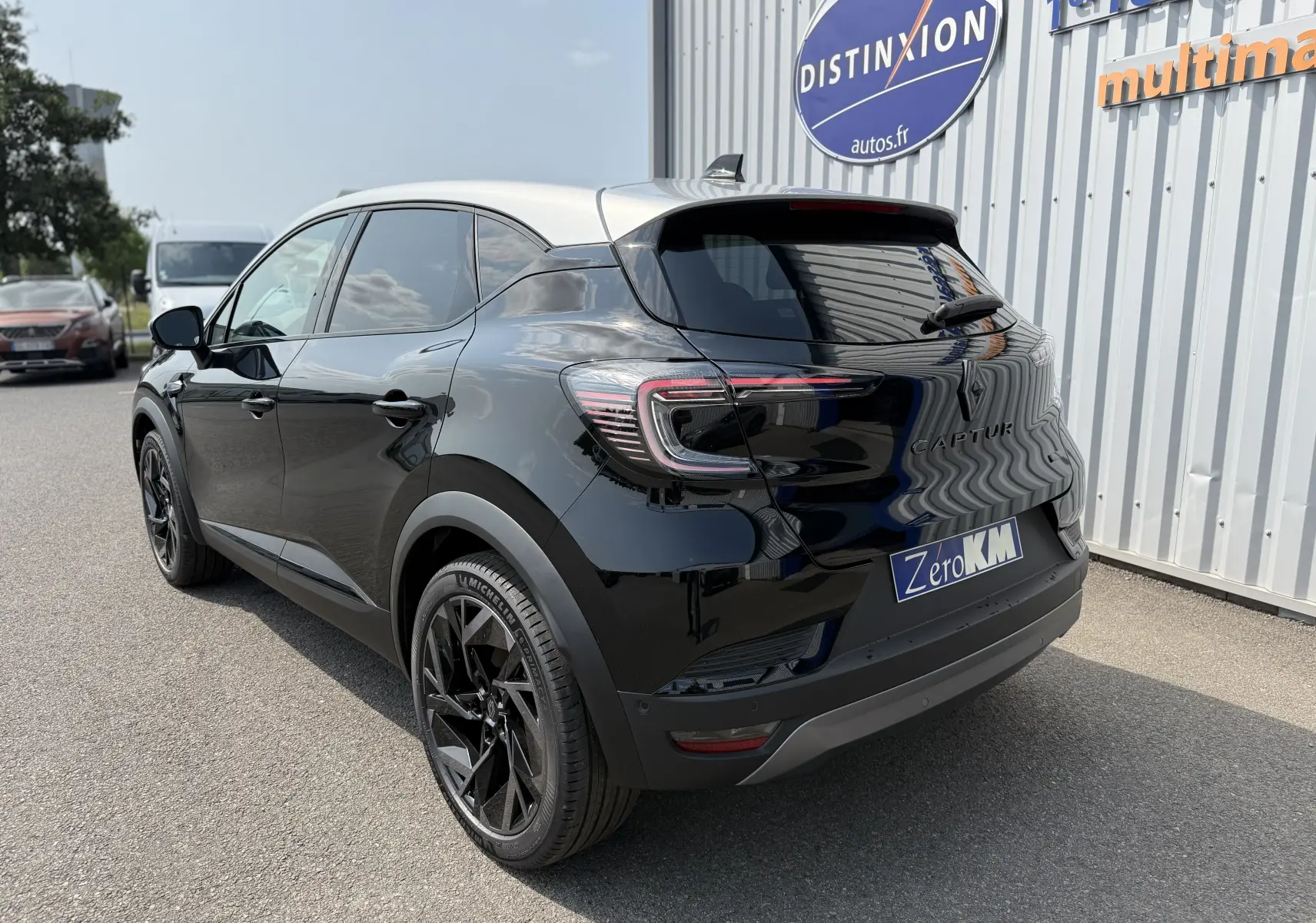 Vue 3/4 arrière droite d'un Renault Captur noir étoile avec toit gris, jantes noires et feux arrière LED distinctifs.