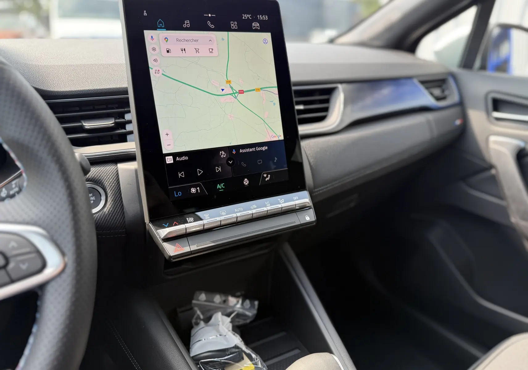 Vue intérieure du tableau de bord du Renault Captur 2025, écran tactile vertical affichant la navigation, finition moderne noire.