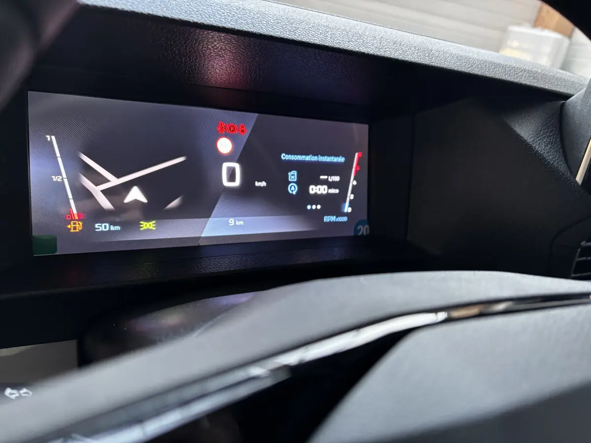 Gros plan sur le tableau de bord numérique du Peugeot Expert Fourgon blanc, affichant la consommation et la vitesse à 0 km/h.