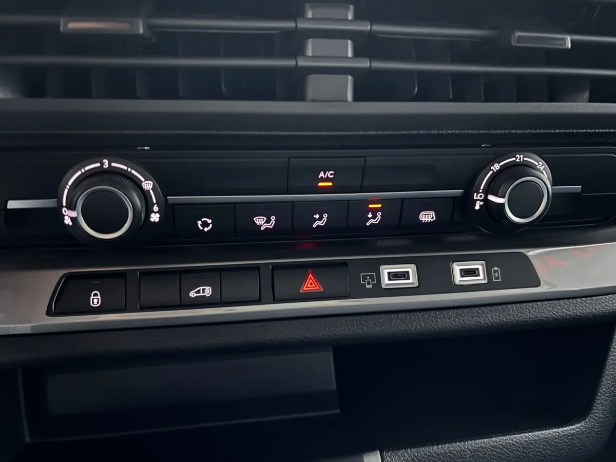 Vue rapprochée de la console centrale du Peugeot Expert Fourgon blanc 2025, avec commandes climatisation et ports USB visibles