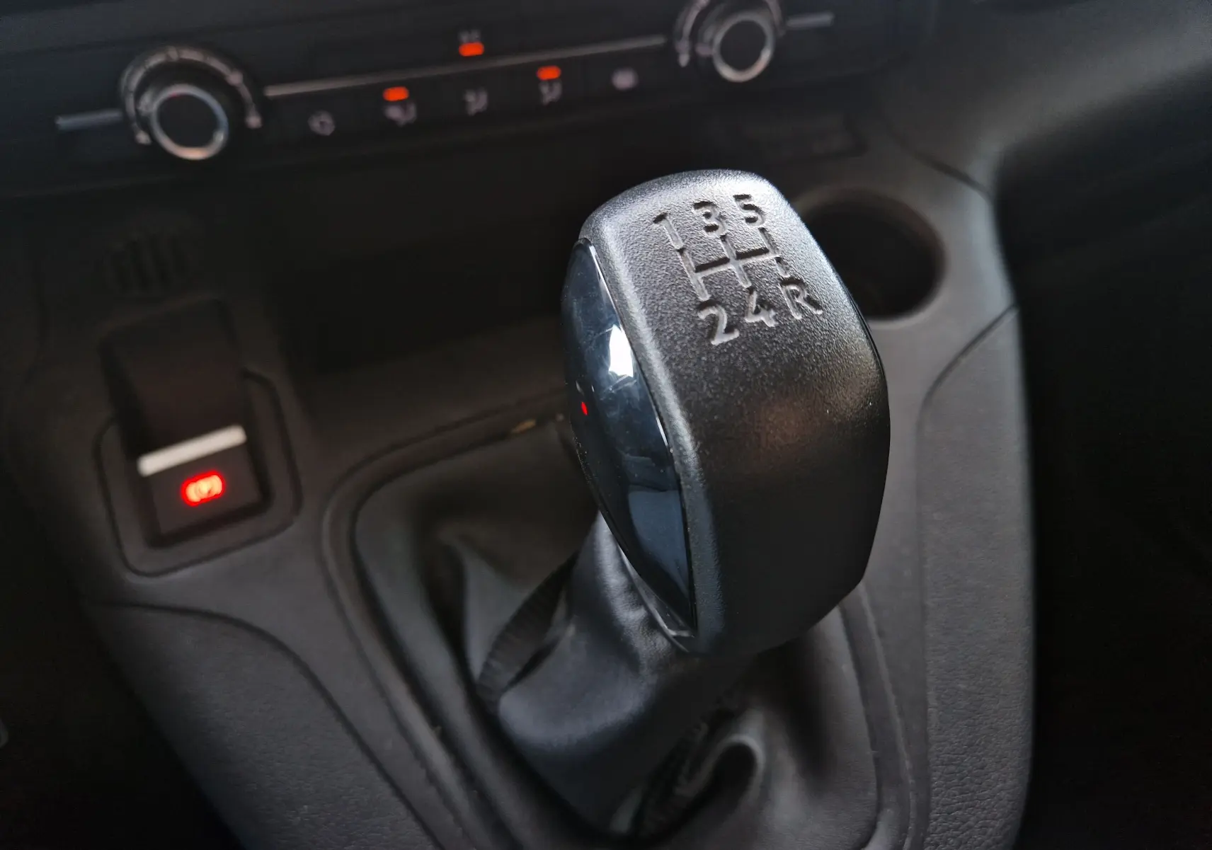 Le levier de vitesses manuel en gros plan dans l'habitacle du Peugeot Partner gris Artense 2021.