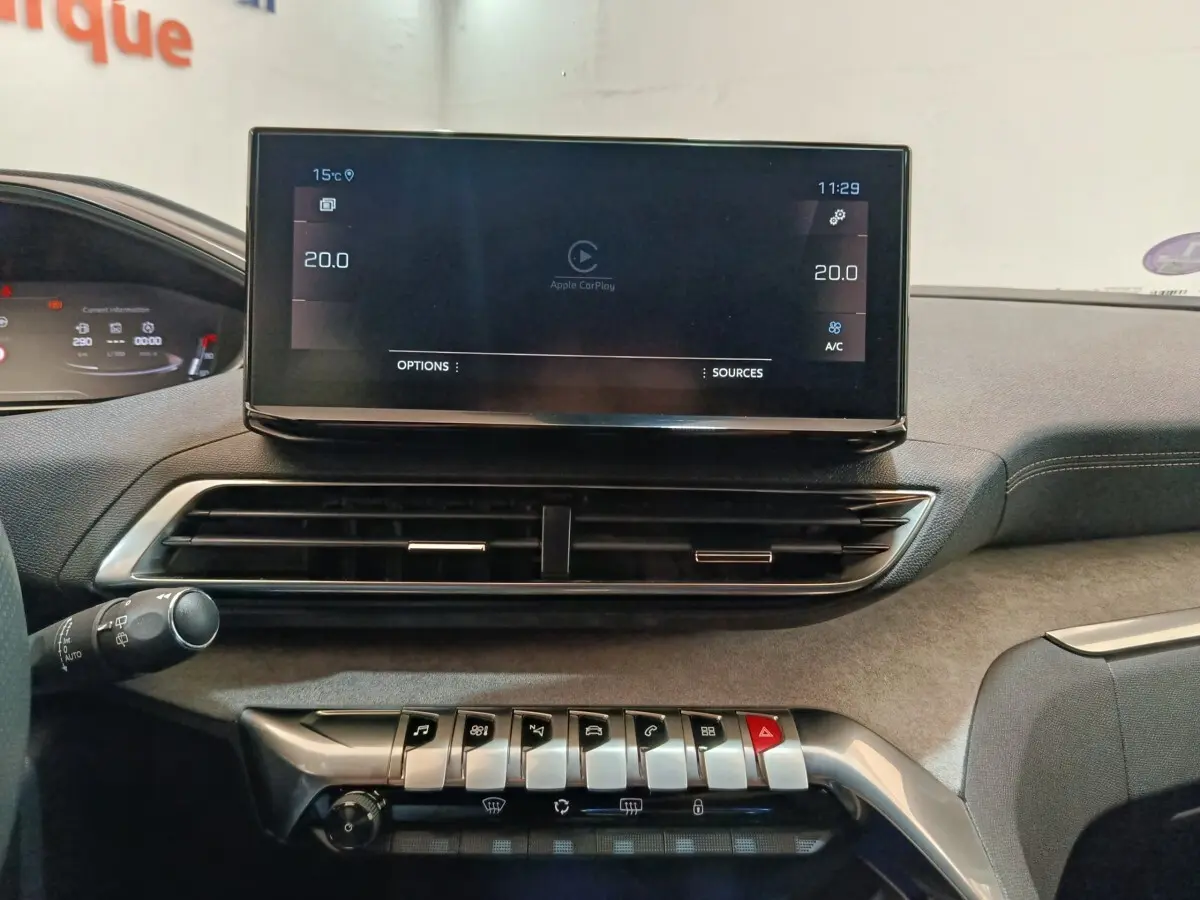 Vue rapprochée de la console centrale du Peugeot 5008 GT 2023, écran tactile et commandes piano visibles.