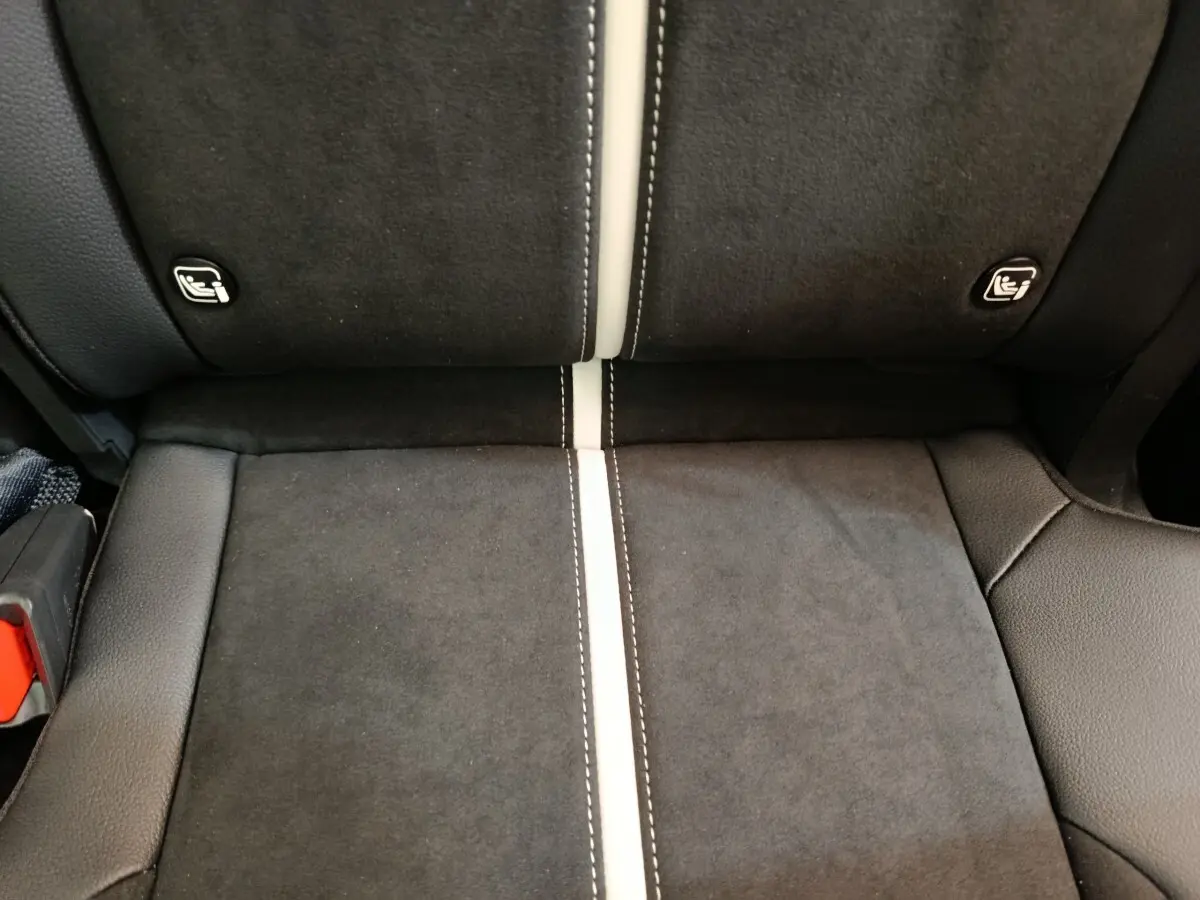 Détail de la banquette arrière en tissu noir avec surpiqûres blanches et fixations Isofix visibles du Kia Sportage 2026.