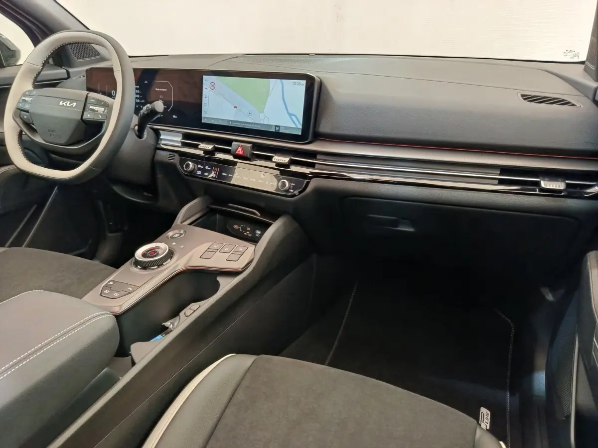 Intérieur du Kia Sportage 2026 vu côté passager, tableau de bord noir avec écran tactile large et volant clair.