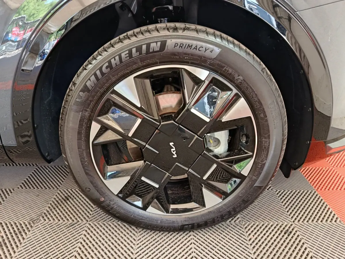 Gros plan sur la roue avant droite gris foncé du KIA SPORTAGE 2026 avec jante noire et argentée au design géométrique.